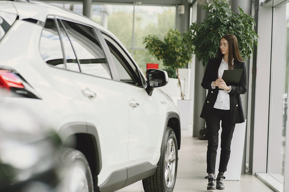 Confident businesswoman with clipboard inspecting car in dealership showroom
